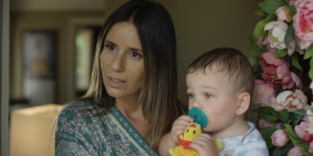 Gigi holding a baby in Bittersweet